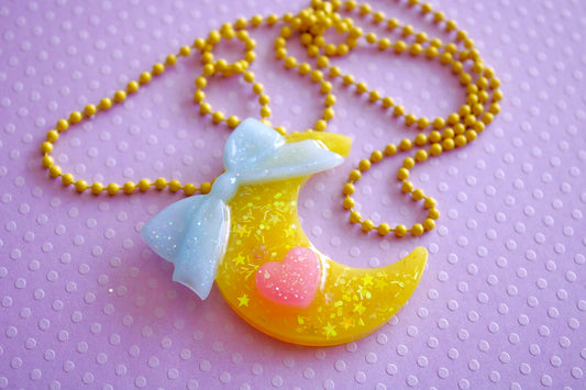 Kawaii fairy kei necklace yumekawaii magical girl sailor moon mahou kei mahou shojo japanese street fashion Harajuku style yellow cresent moon necklace with a blue bow and pink heart cutecore jojifuku 